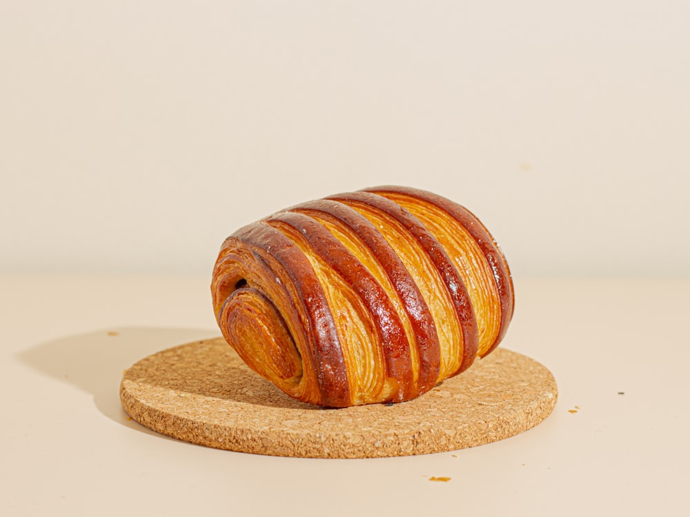 a piece of bread sitting on top of a cork coaster