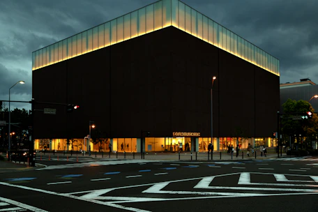 Modern commercial facade with sleek dark tones and premium lighting at dusk.