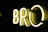 Brightly illuminated letters 'BRO' in neon lights against a dark background, casting a soft glow.