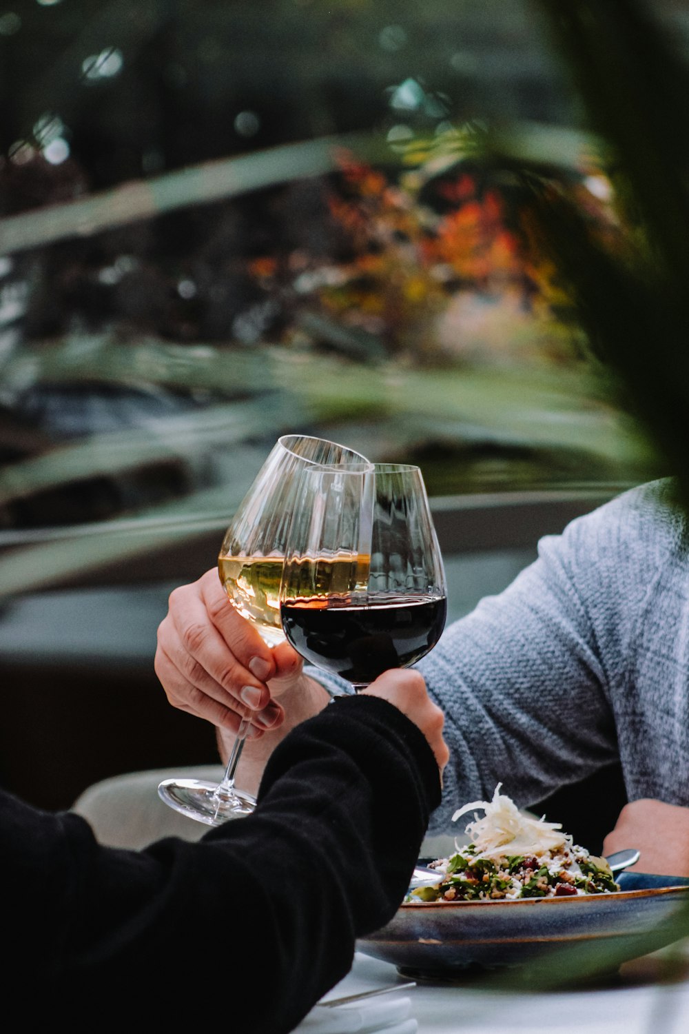 a couple of people sitting at a table with a glass of wine