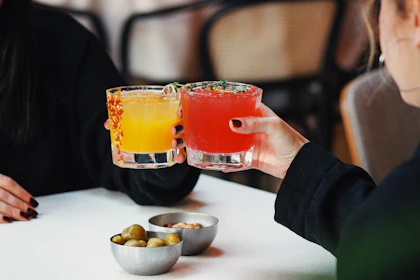 a couple of people sitting at a table with drinks