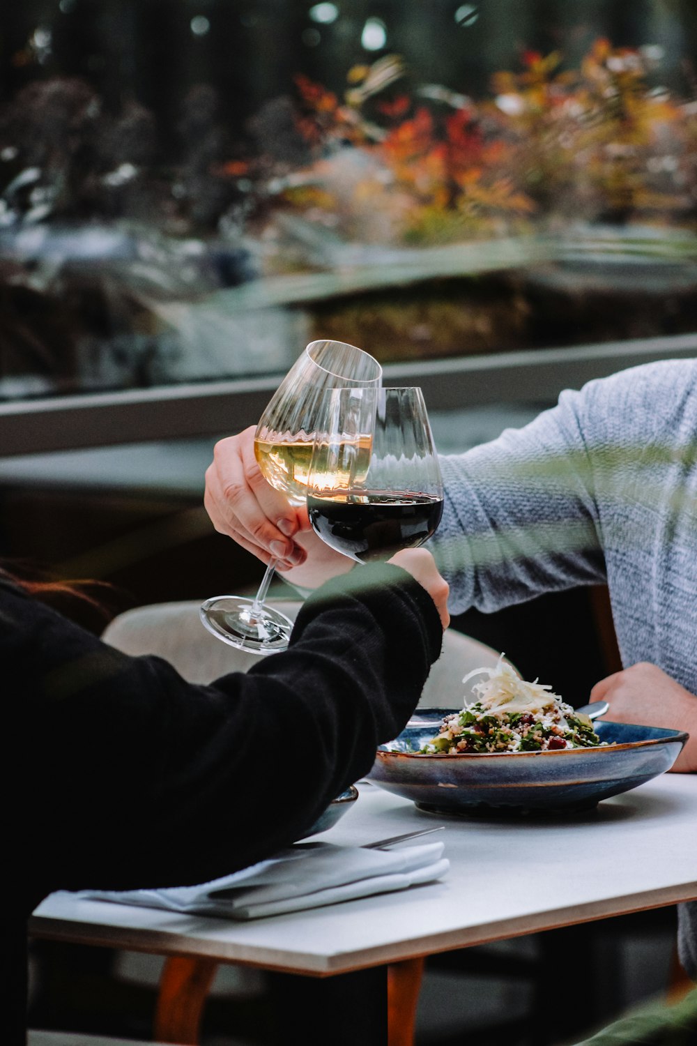 a couple of people sitting at a table with a glass of wine