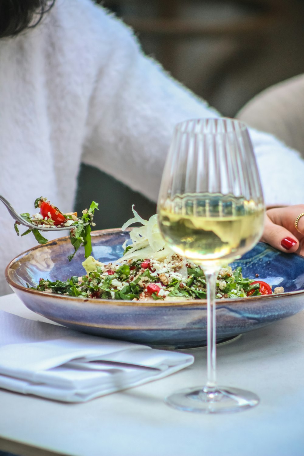 a plate of food and a glass of wine on a table