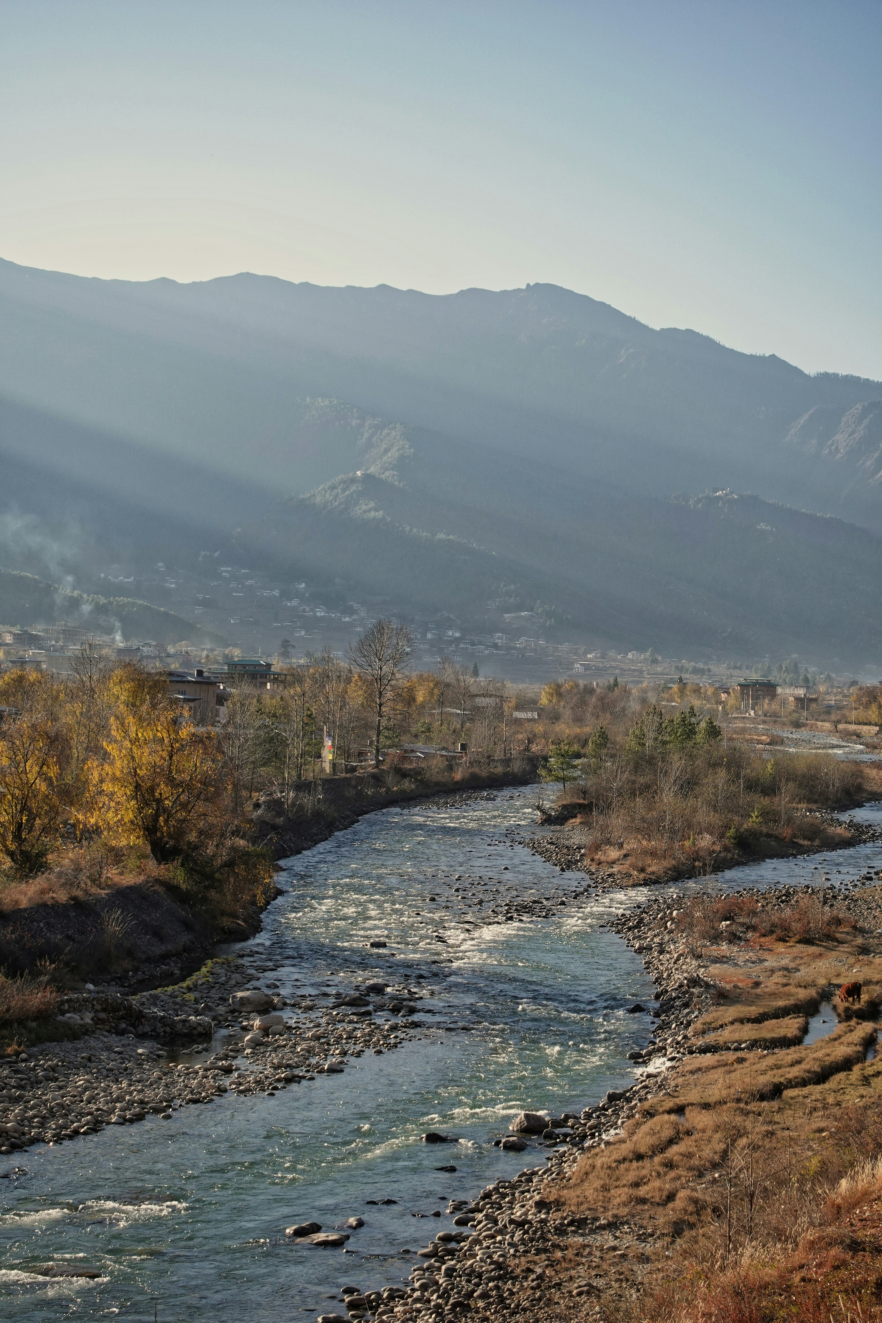 a river running through a lush green hillside