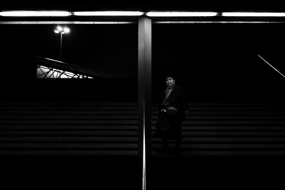 a man in a suit and tie standing in a dark room