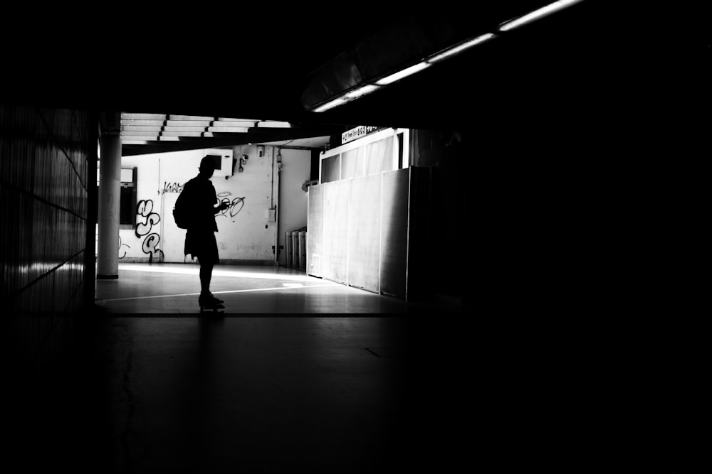 a person standing in a dark tunnel with a cell phone