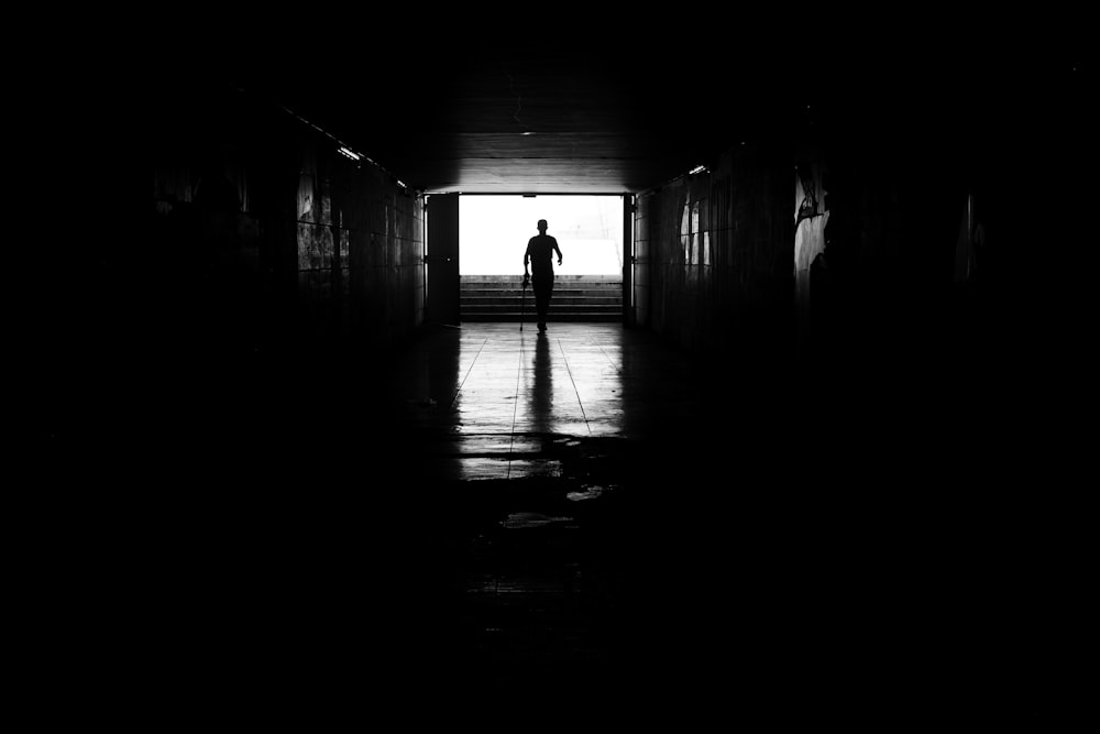 a man is standing in a dark hallway