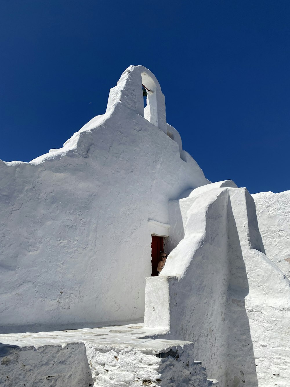 a white building with a red door and window