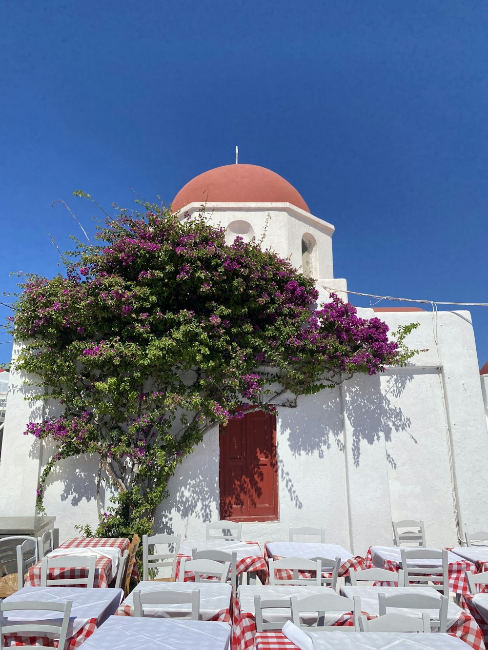 a white building with a red and white checkered table and chairs