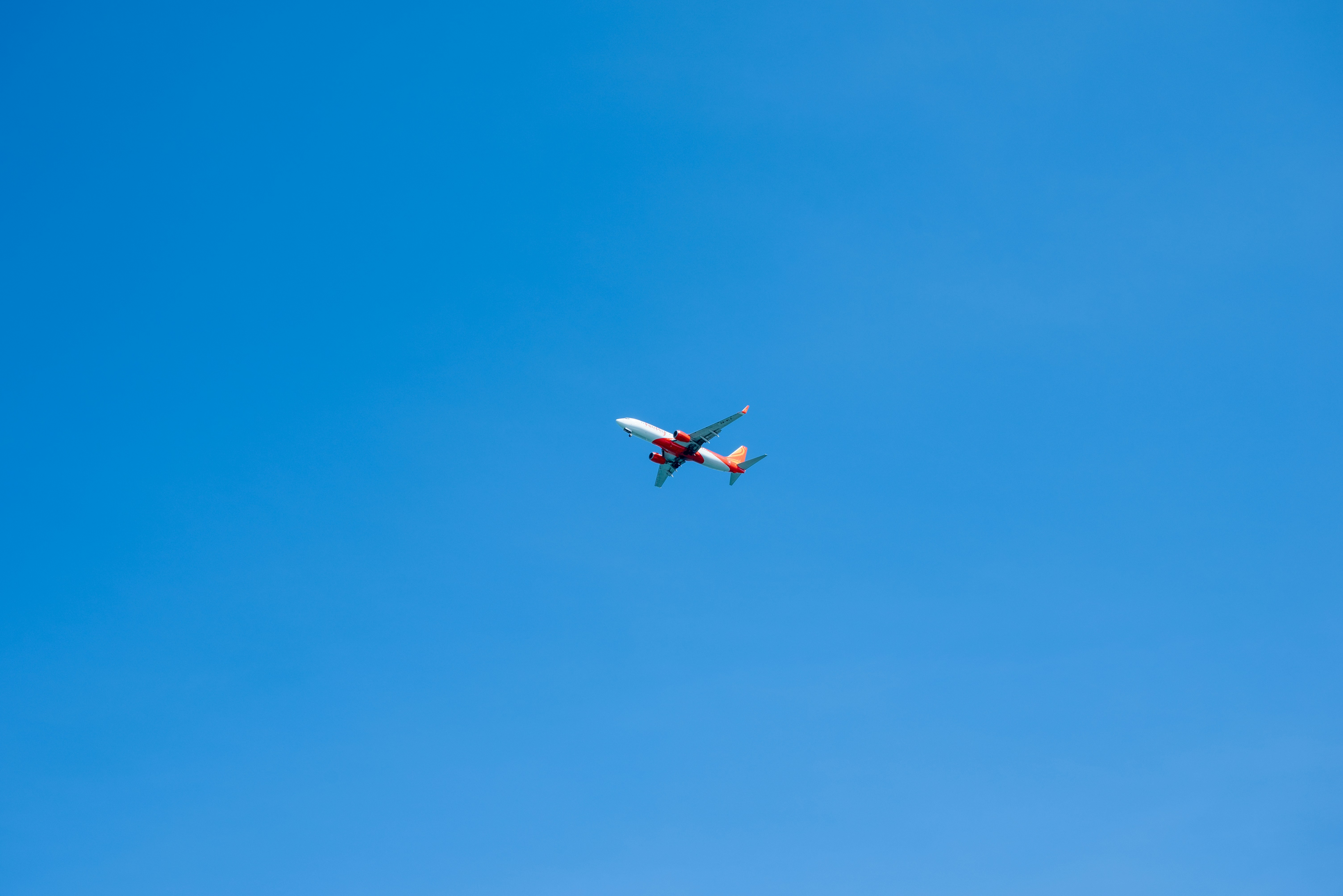 an airplane is flying in the blue sky, 