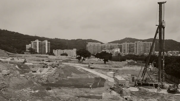 Wide shot of heavy machinery installing monitored continuous flight auger piles at a medium-sized building project