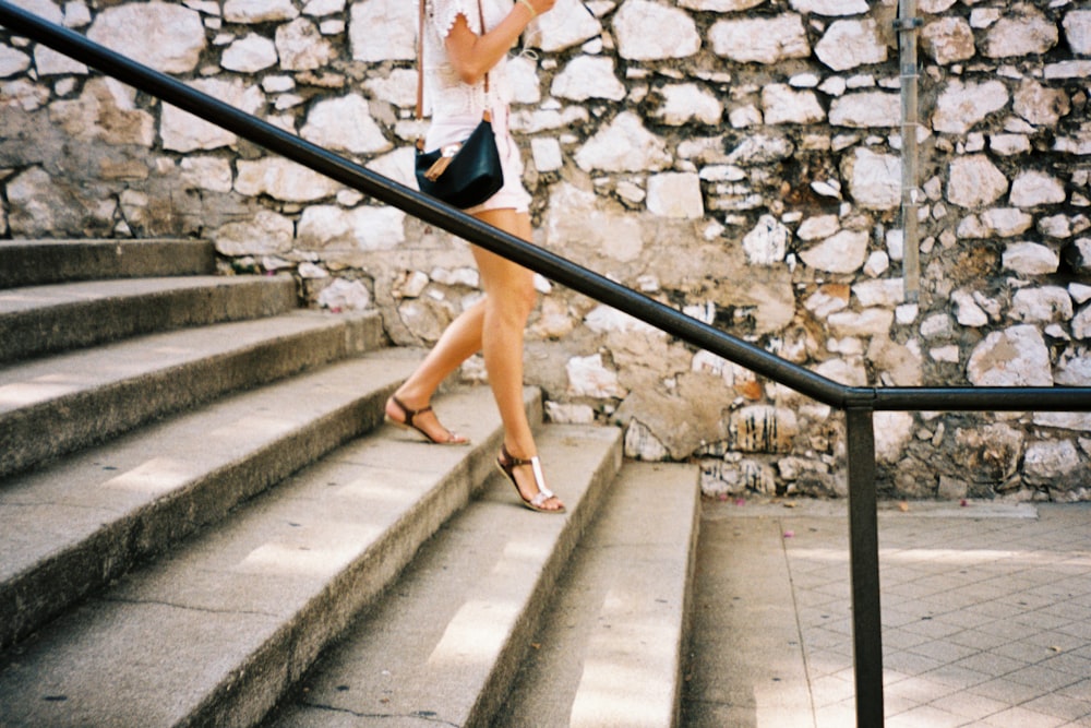 a woman is walking down a set of stairs