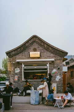 Cozy local cafe storefront with customers ordering on their phones.