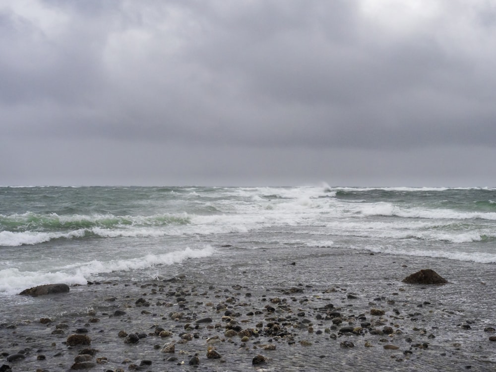 a rocky beach with waves coming in to shore