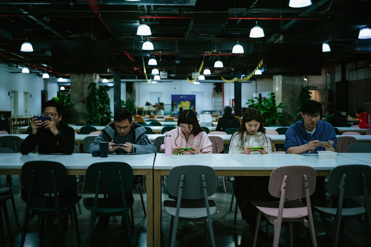 Friends and family gathered around a table with their phones