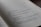 A close-up view of a book page with Chinese text in black ink. The page is slightly curved, indicating that the book is open. The lighting is soft and creates subtle shadows on the page, giving it a natural and somewhat intimate feel. The background is out of focus, emphasizing the text on the page.