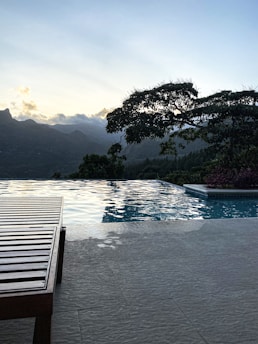 a wooden bench sitting next to a swimming pool