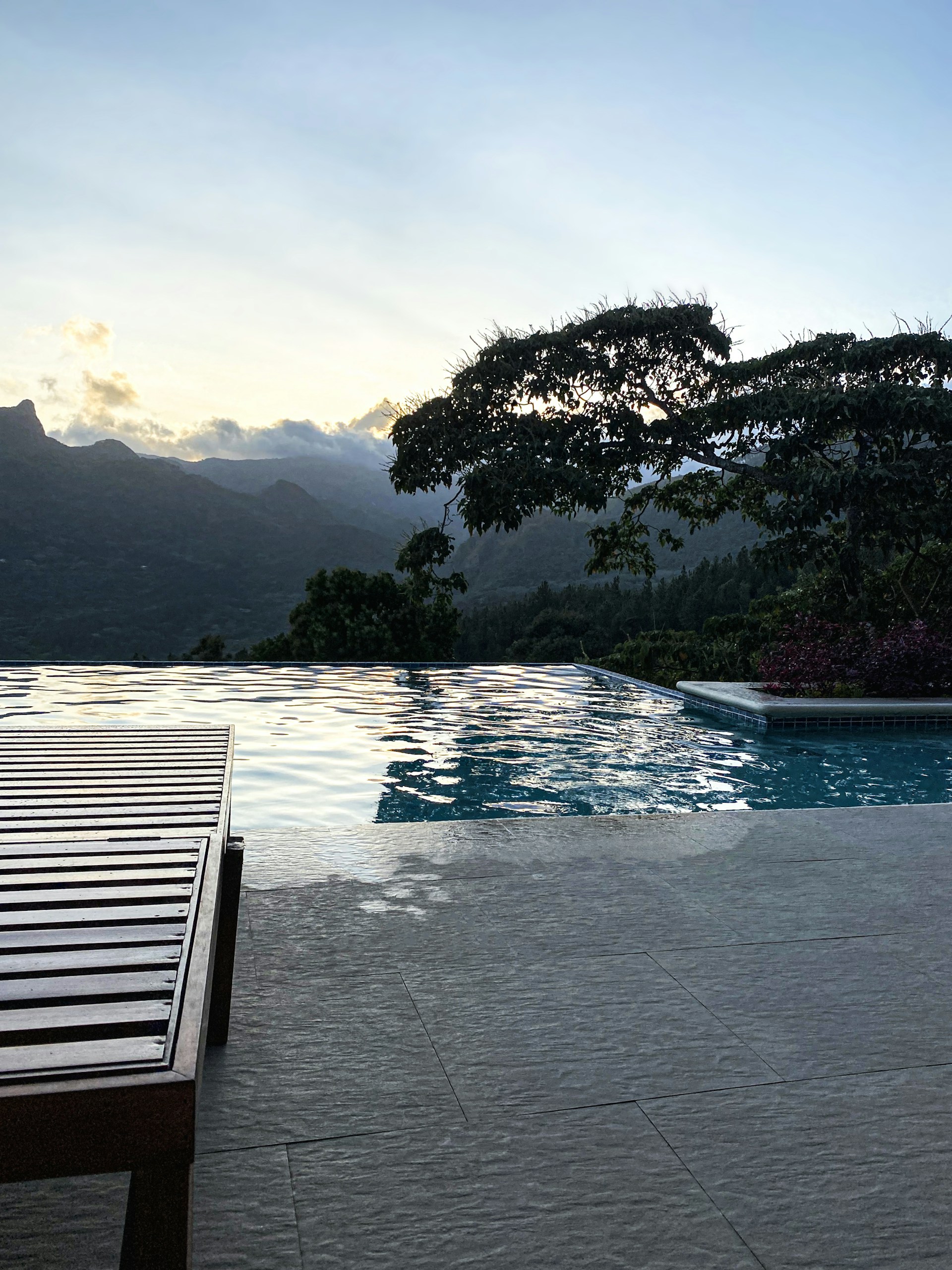 a wooden bench sitting next to a swimming pool