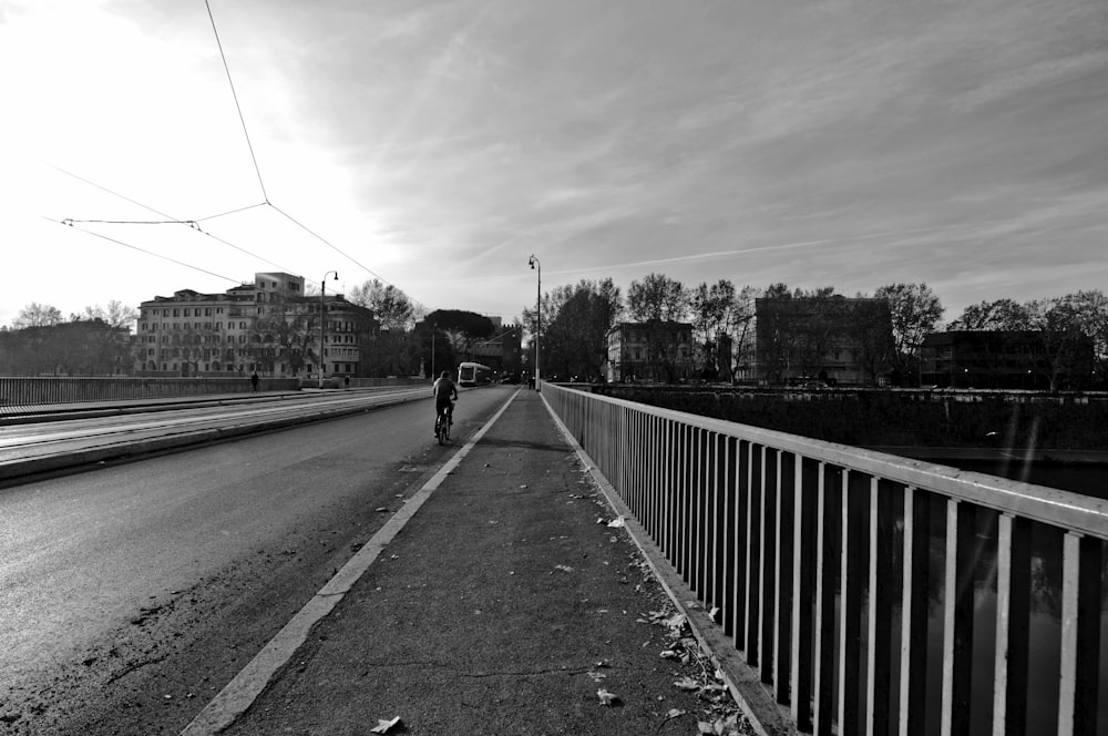 a black and white photo of a person riding a bike