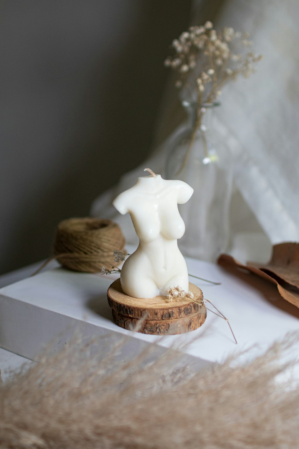 a white candle sitting on top of a white box