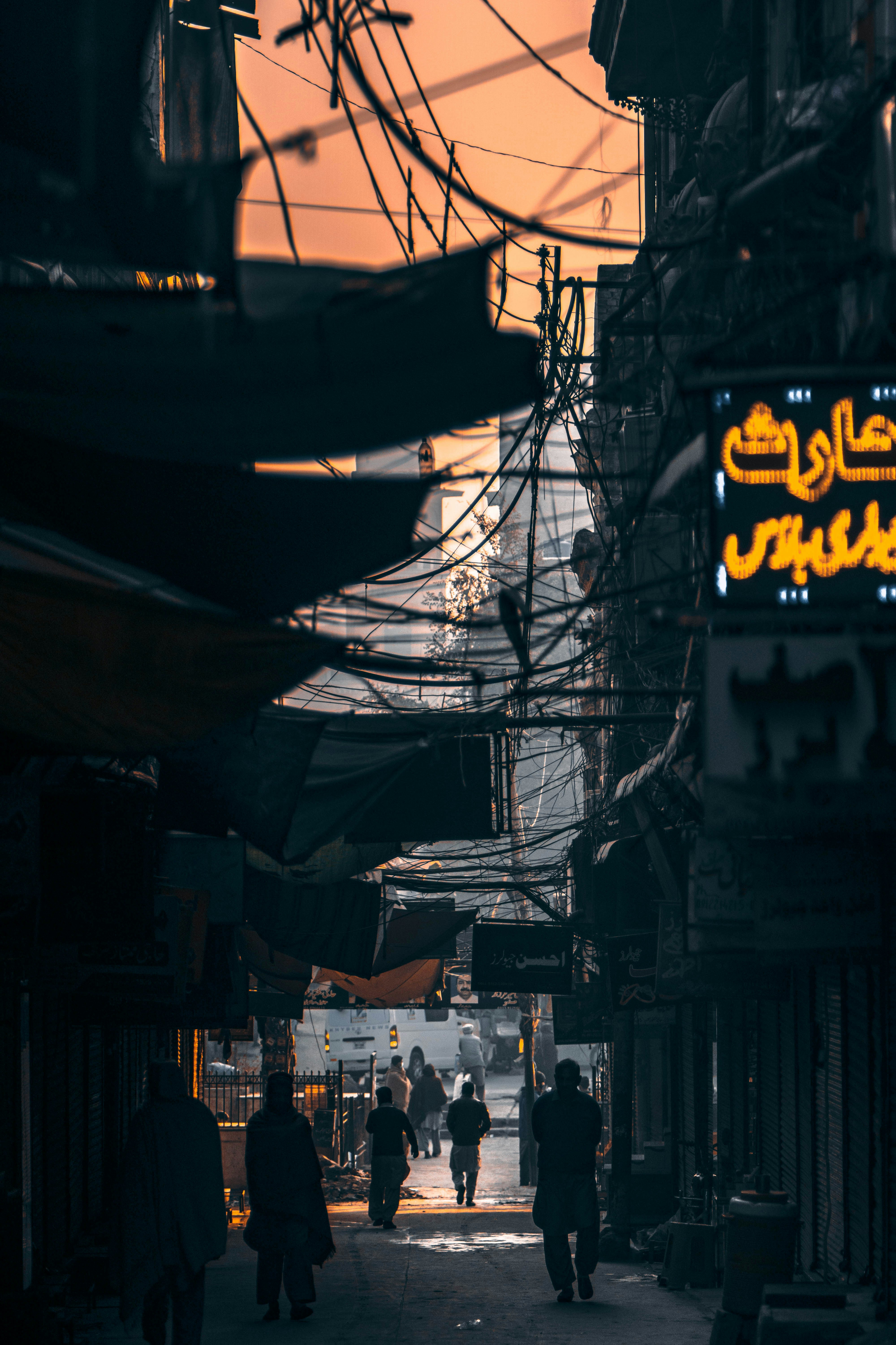 a group of people walking down a street under power lines