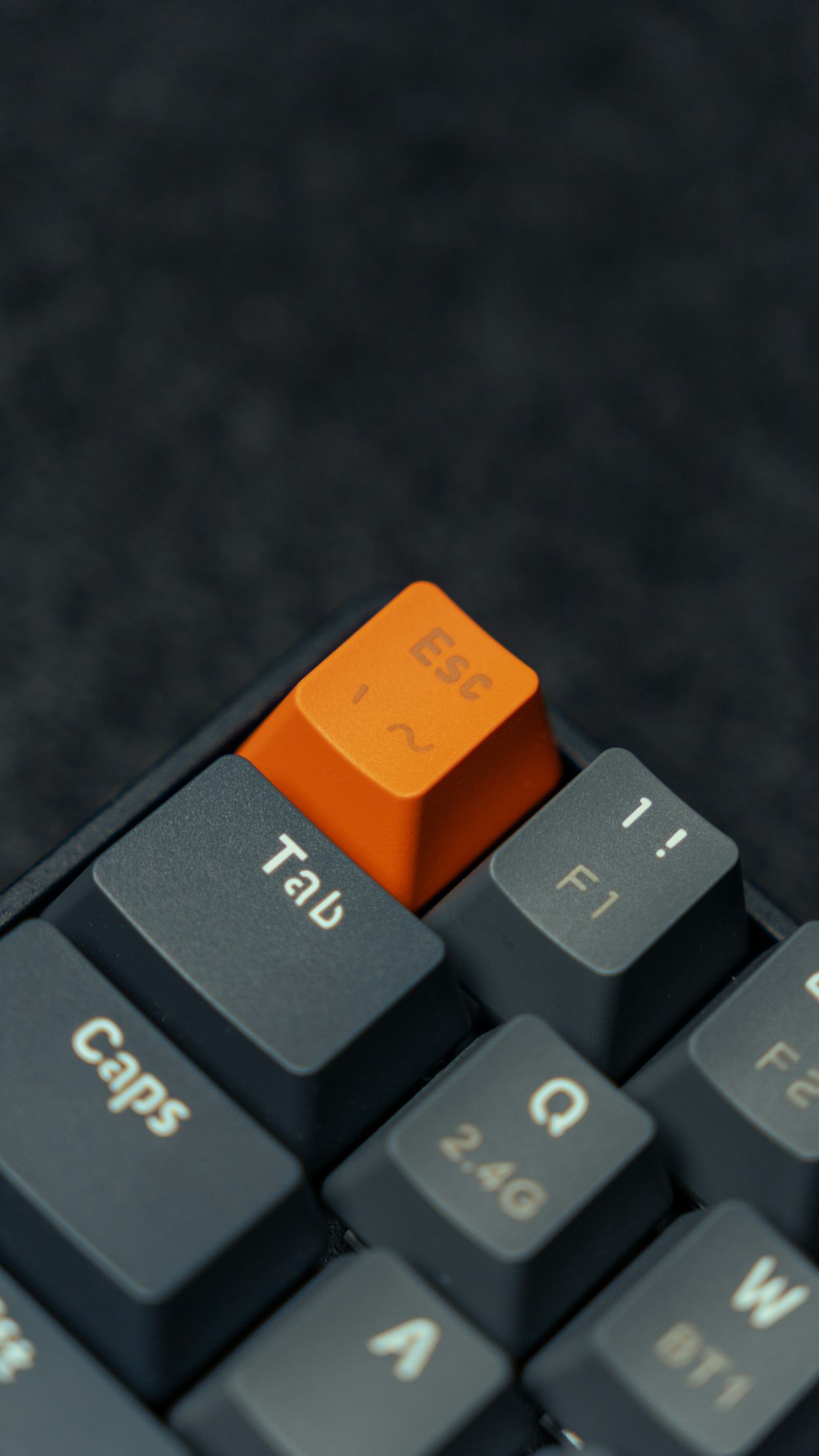 a close up of a computer keyboard with an orange key