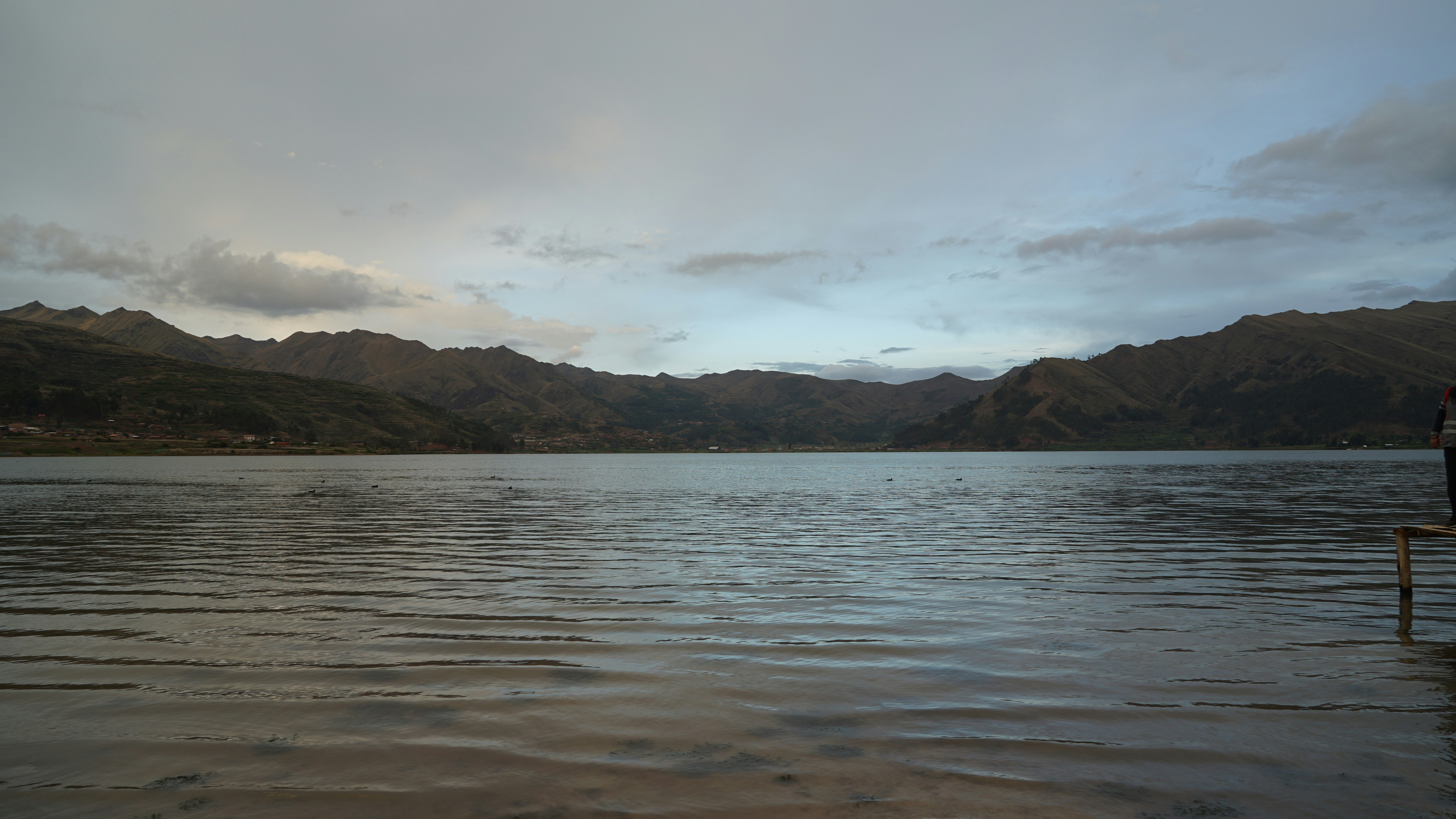 a man standing on a dock in the middle of a lake
