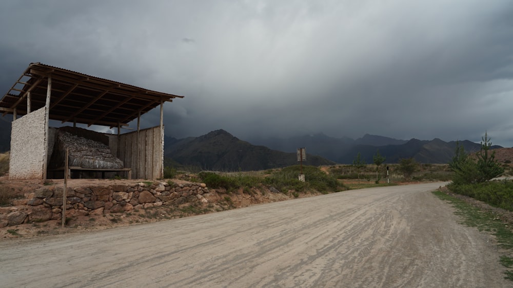 a dirt road with a building on the side of it