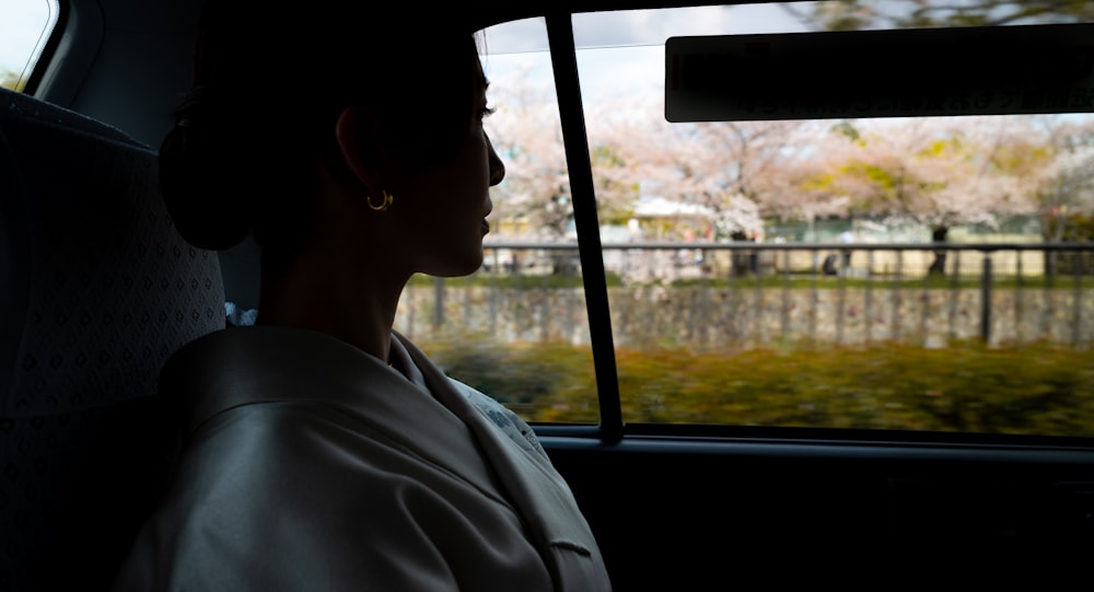 a woman sitting in a car looking out the window