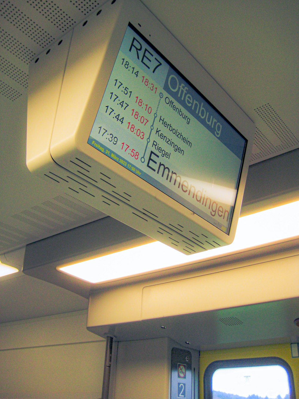 a tv mounted to the ceiling of a train