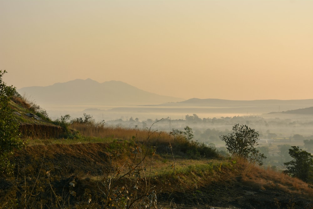 a view of a foggy valley with mountains in the distance