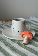 A cozy nook filled with charming cat-themed mugs and teacups, perfect for a quiet moment with your feline friend.