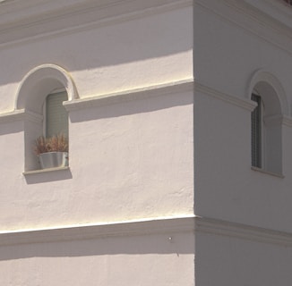 Wide shot of a residential exterior wall with decorative masonry and smooth plaster.