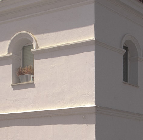 Wide shot of a residential exterior wall with decorative masonry and smooth plaster.