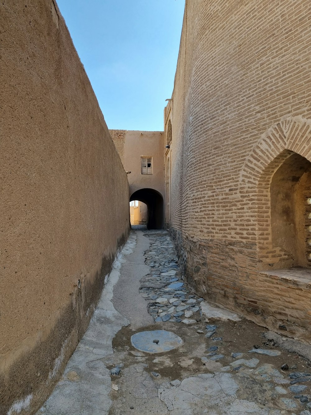 a narrow alley between two brick buildings