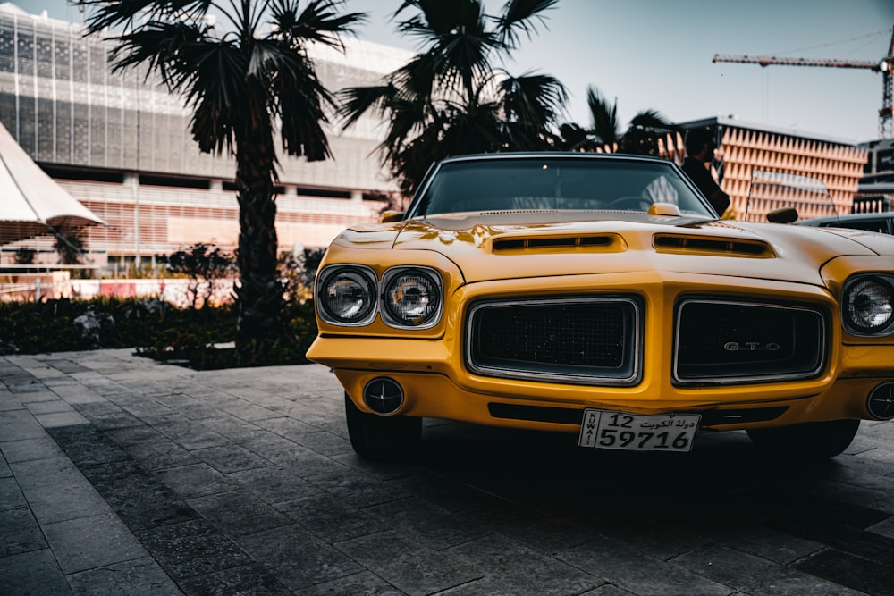 a yellow car is parked on the side of the road