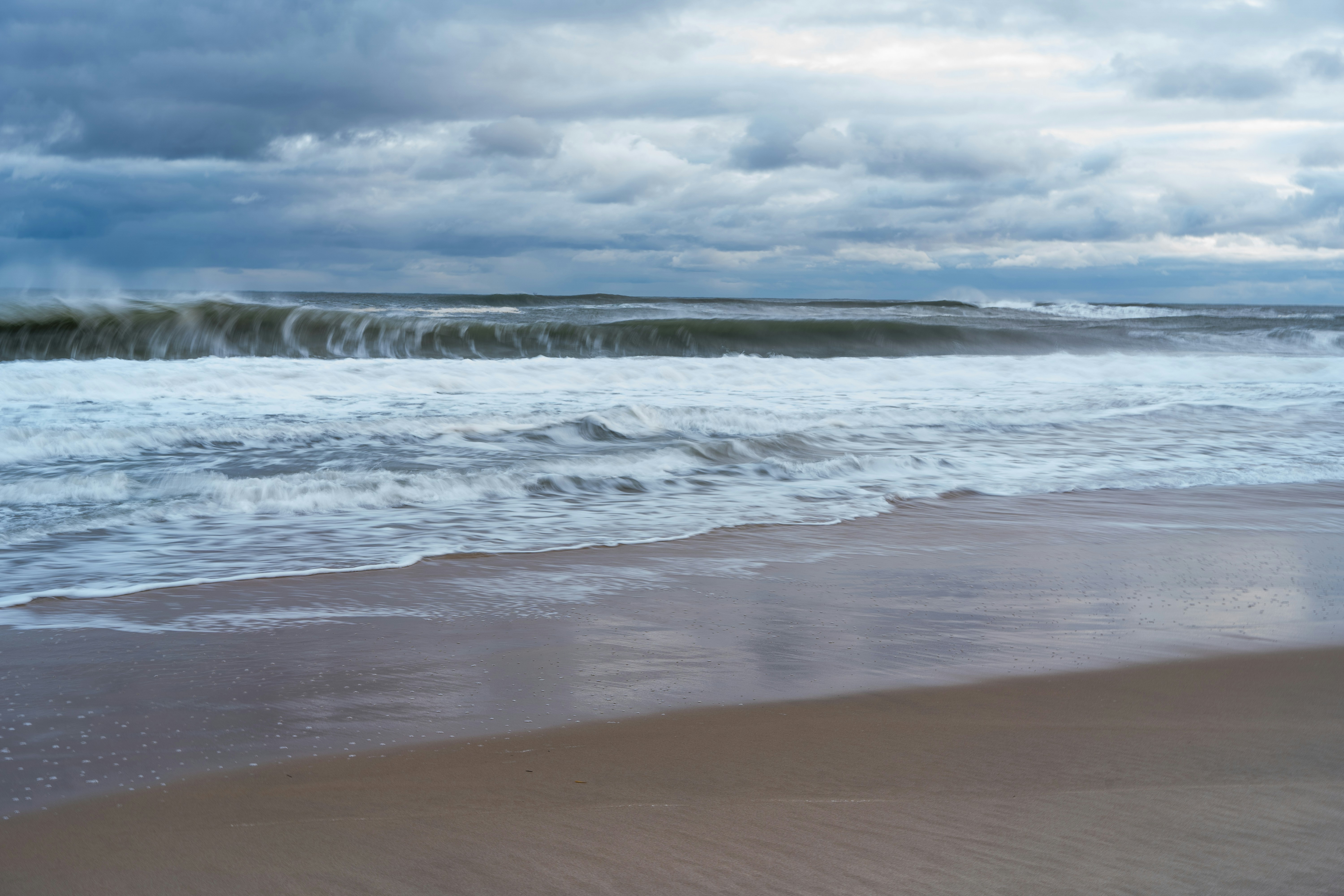 a large body of water sitting on top of a sandy beach