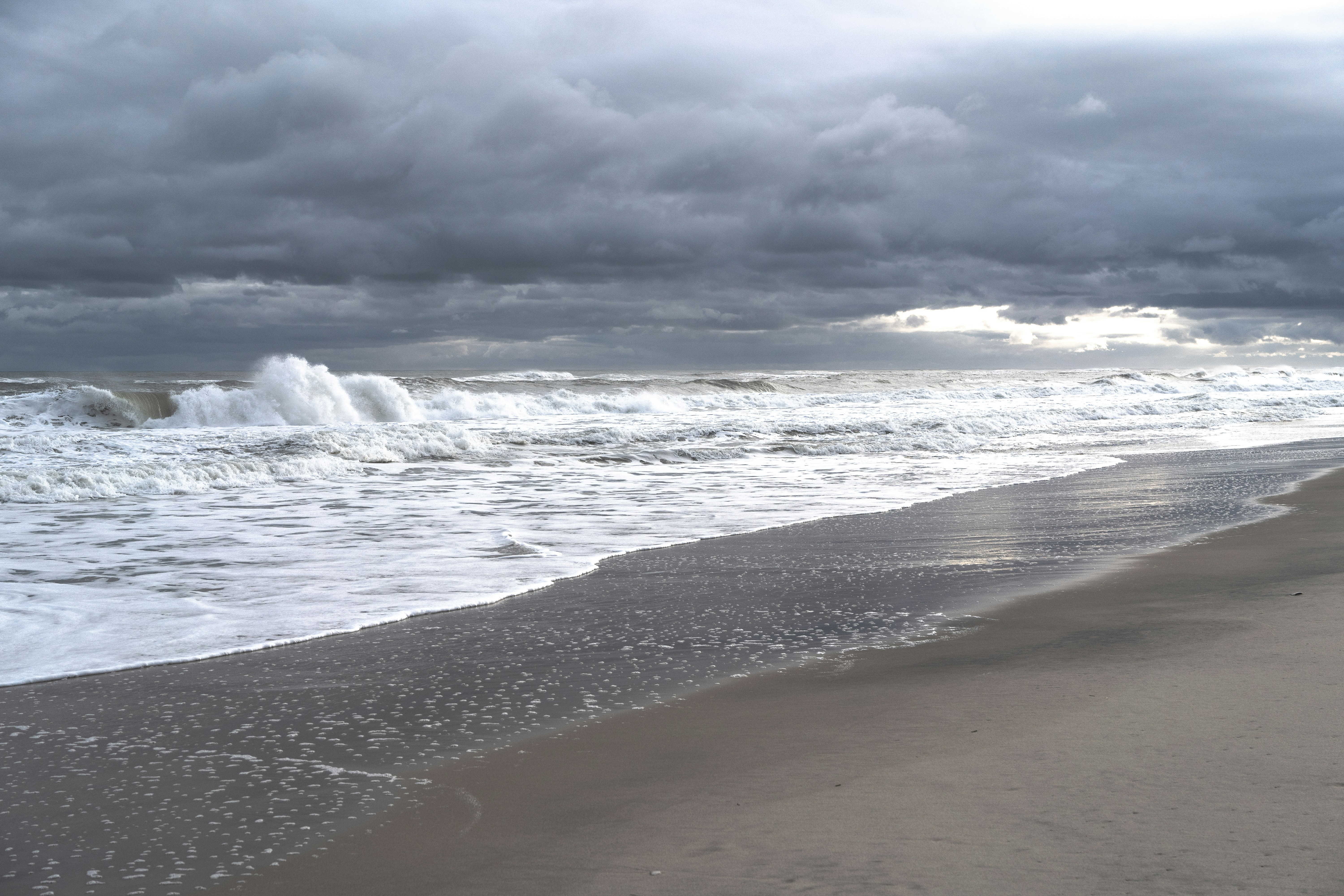a person walking along a beach next to the ocean