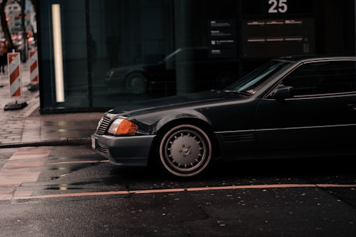 A sleek matte black tow truck with Reignwater Detailing branding parked in a city street.