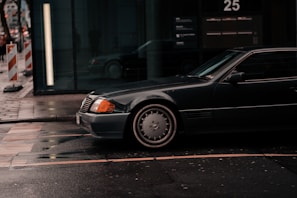 A sleek black taxi car parked on a city street.