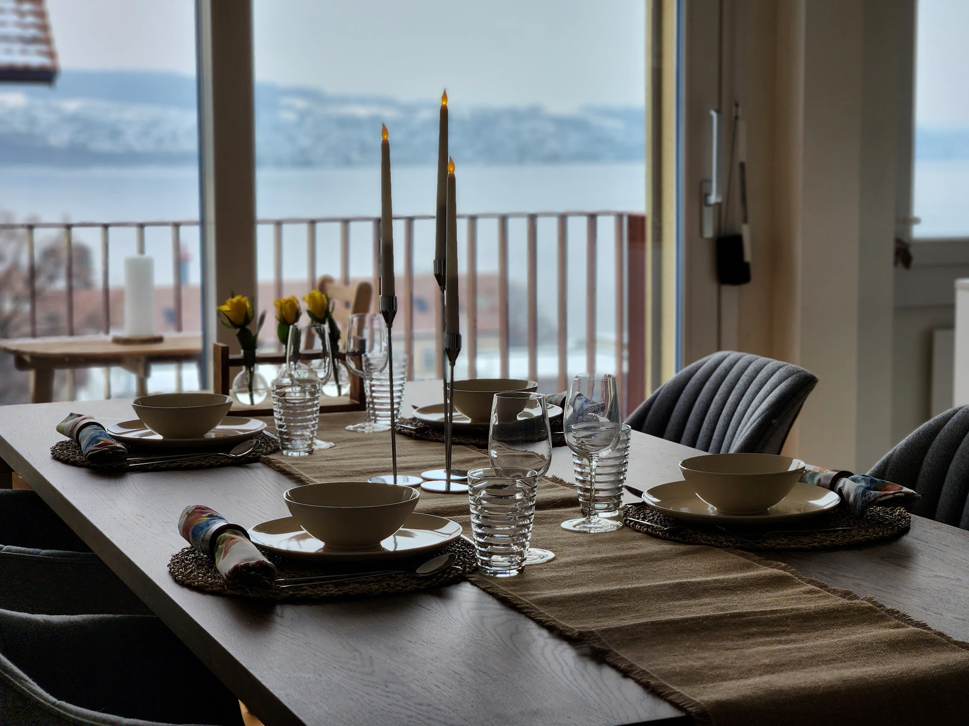 An elegant table set for a gourmet dinner at a top restaurant, with a view of the snowy slopes outside.