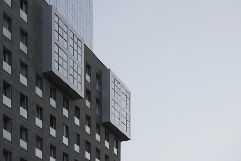 a tall building with windows and a sky background