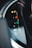 Close-up view of a car's gear shift indicator with visible symbols for park, reverse, neutral, and drive modes. The indicator lights are illuminated, and there are markings for manual shifting options.