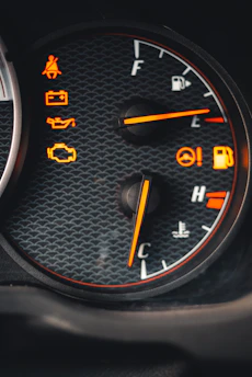 A close-up of a car dashboard with warning lights illuminated, symbolizing automotive fraud alerts.
