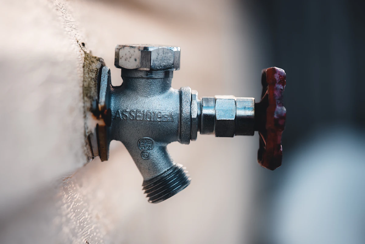 Close-up of a wall-mounted water shutoff valve, the first step on a burst-pipe emergency call