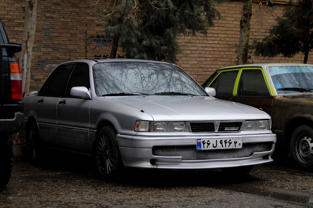 two cars parked next to each other in front of a brick building