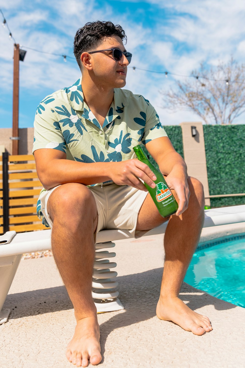 a man sitting on a bench next to a pool