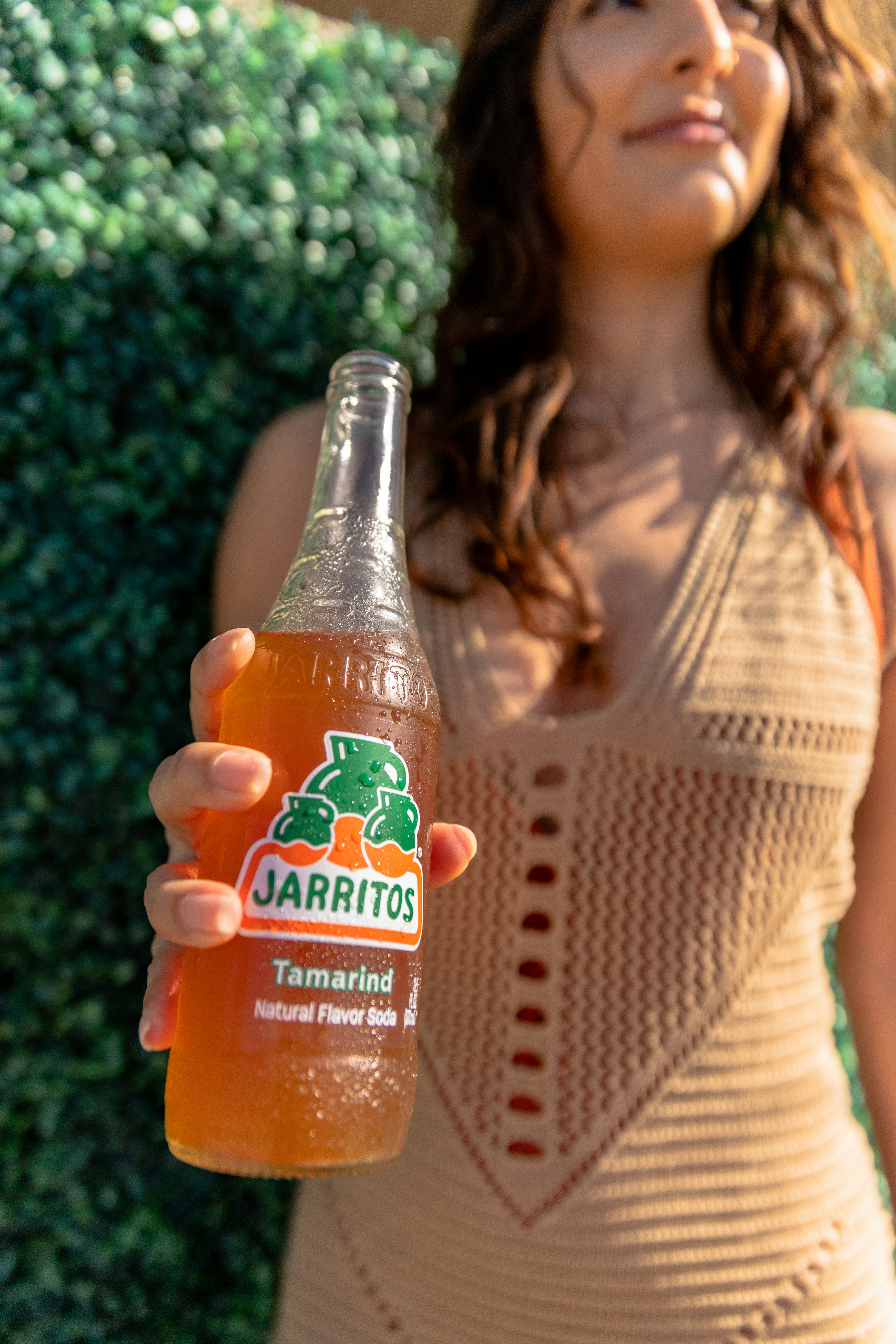 a woman holding a bottle of orange juice