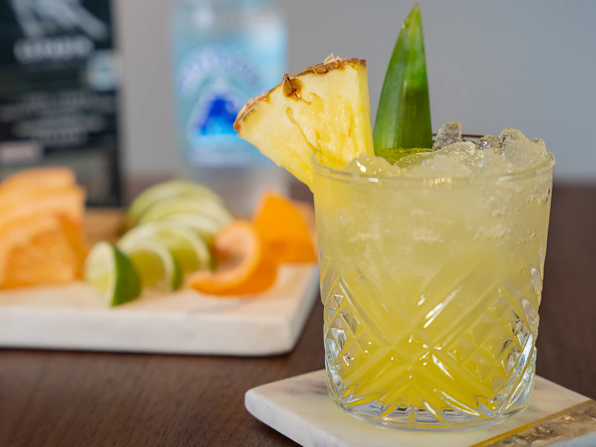 A glass with a pineapple garnish sitting on a table