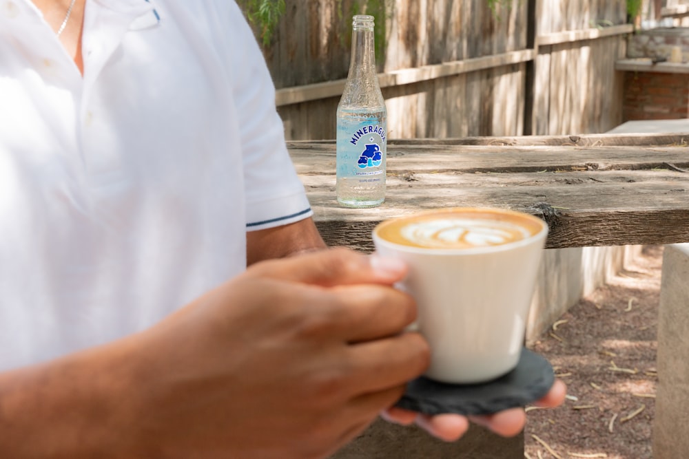 Un hombre sosteniendo una taza de café en la mano